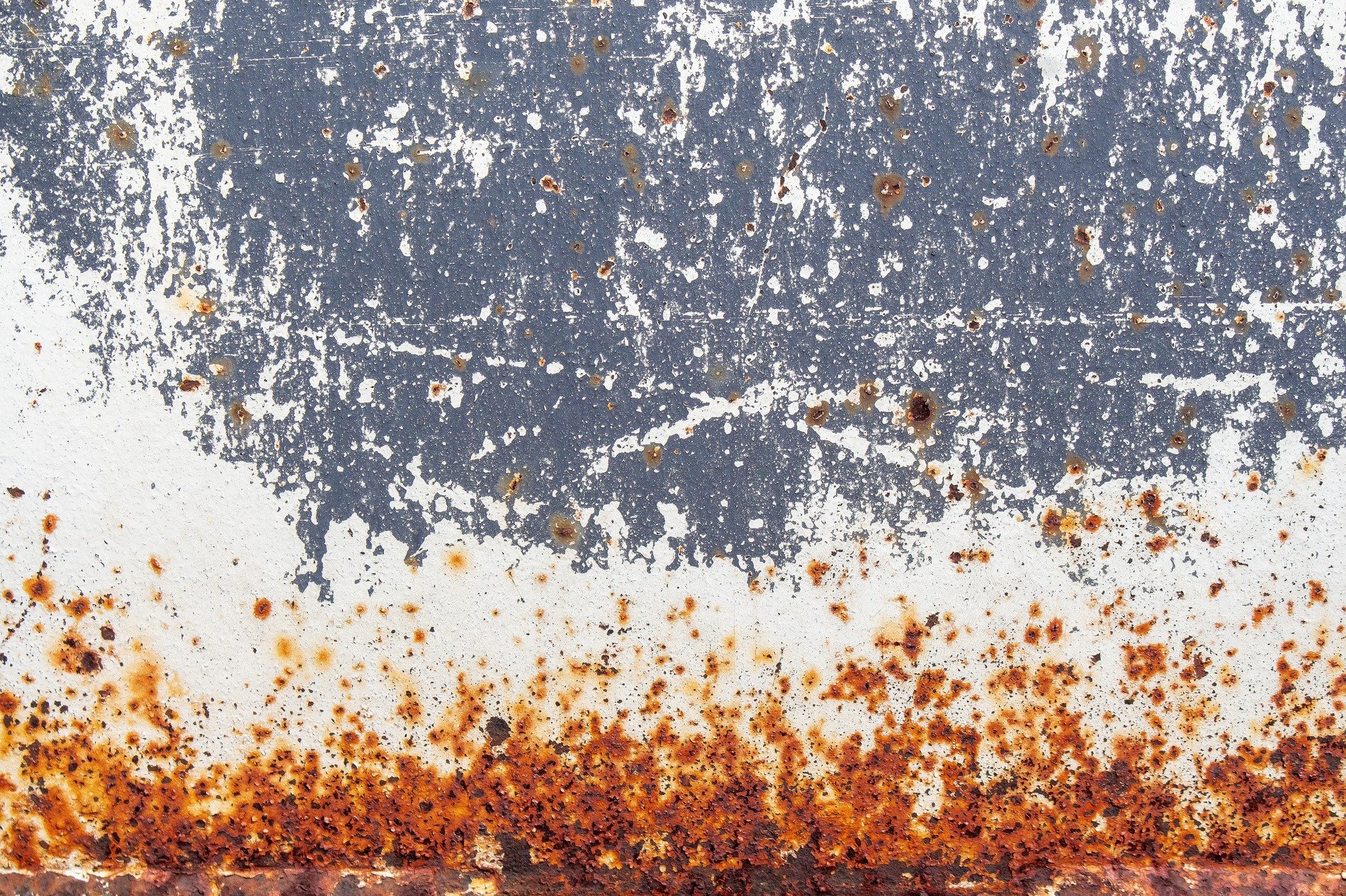 White chips on the blue, metal skin begins to peel, orange rust takes hold