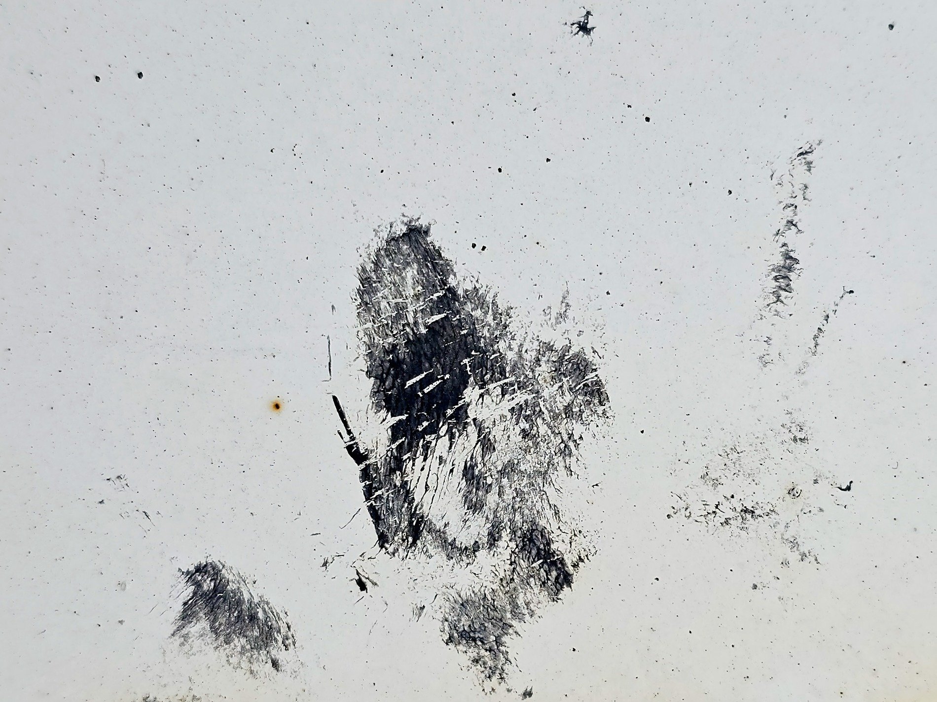 White paint fades away, dark scars mar the empty space, metal shows its age