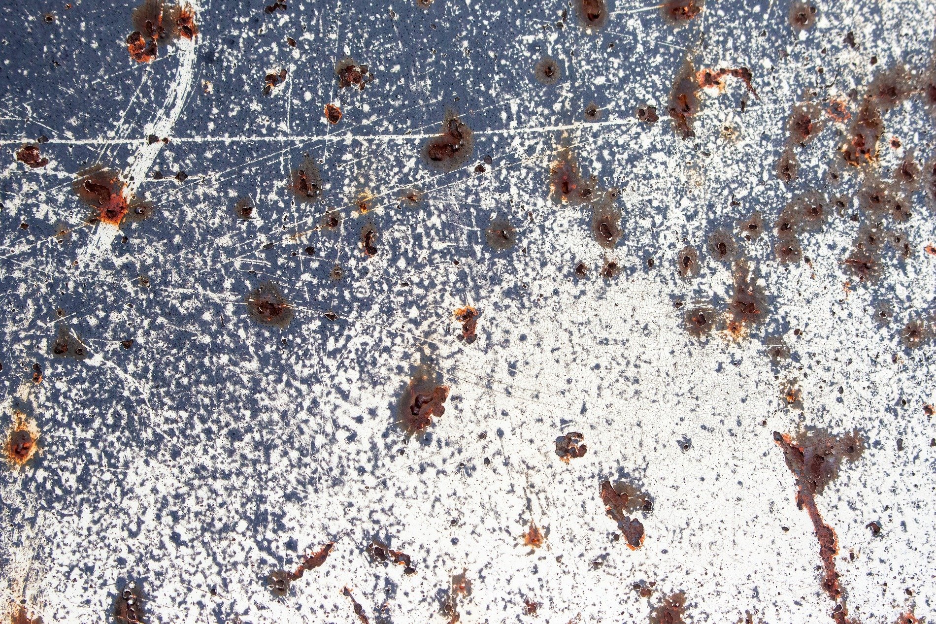 Blue paint peels away, white cracks like a frozen lake, iron turns to rust