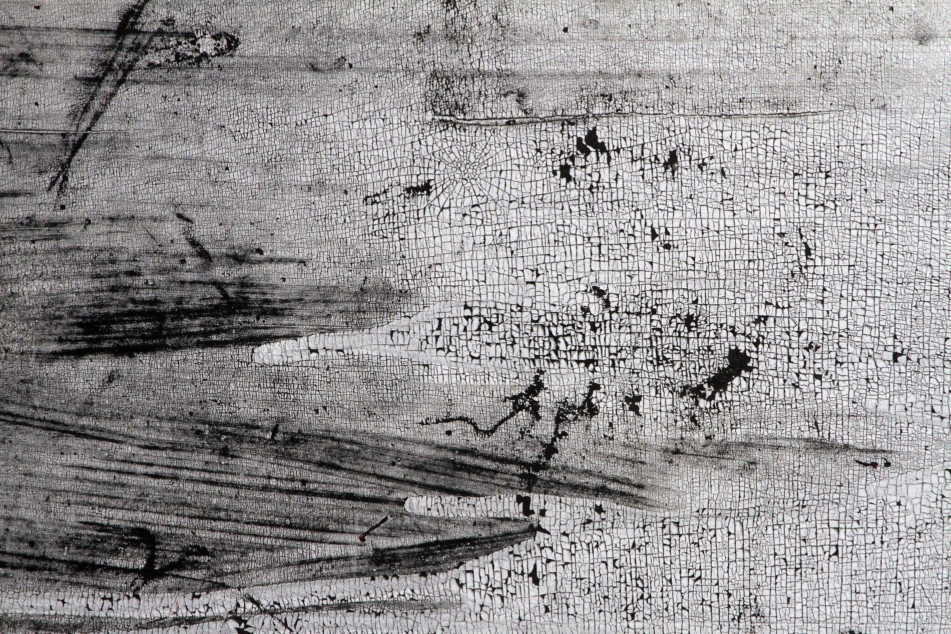 White skin flakes away, black scars trace the heavy field, grit marks the finish