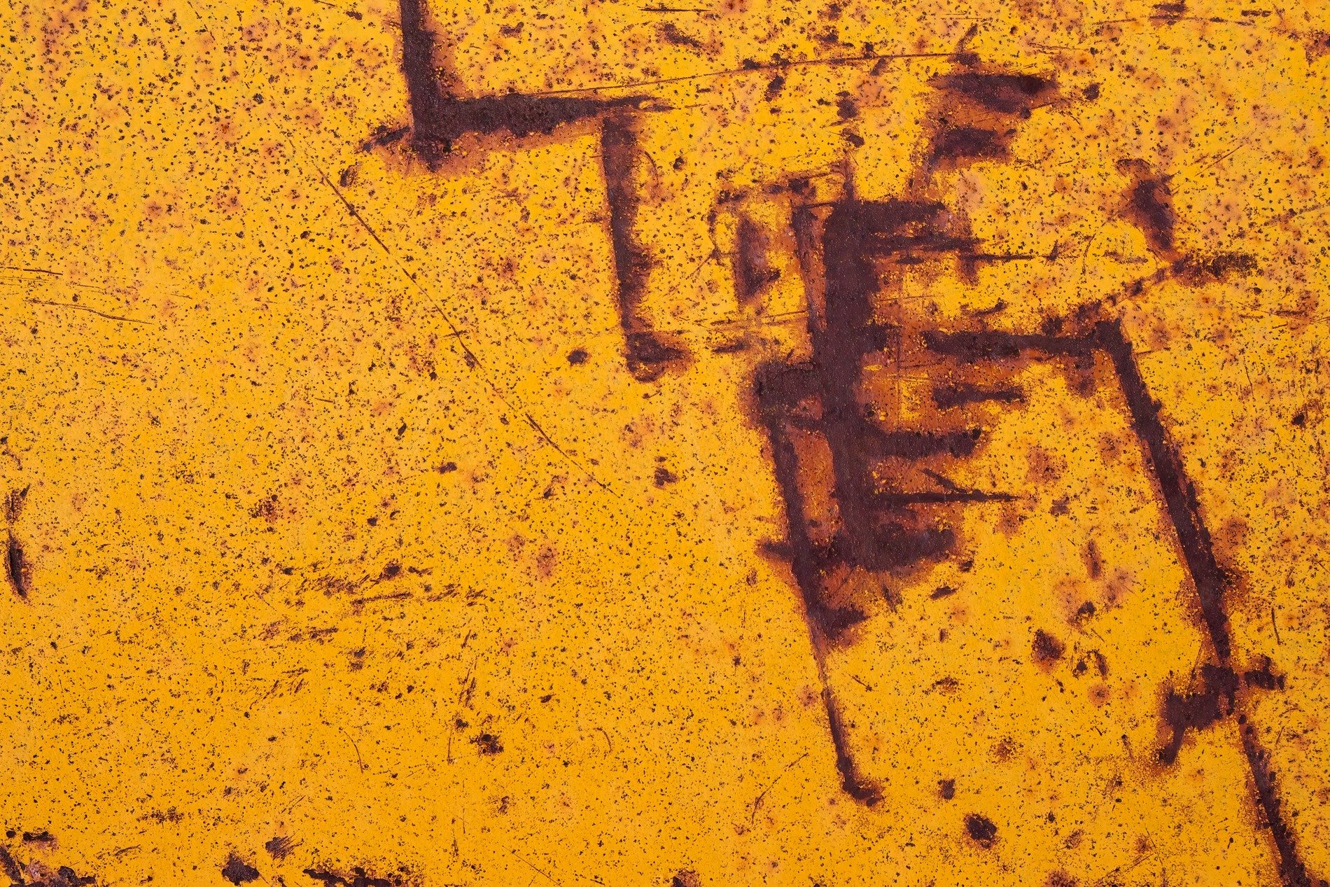 Yellow skin decays, dark iron bleeds through the paint, cryptic marks remain