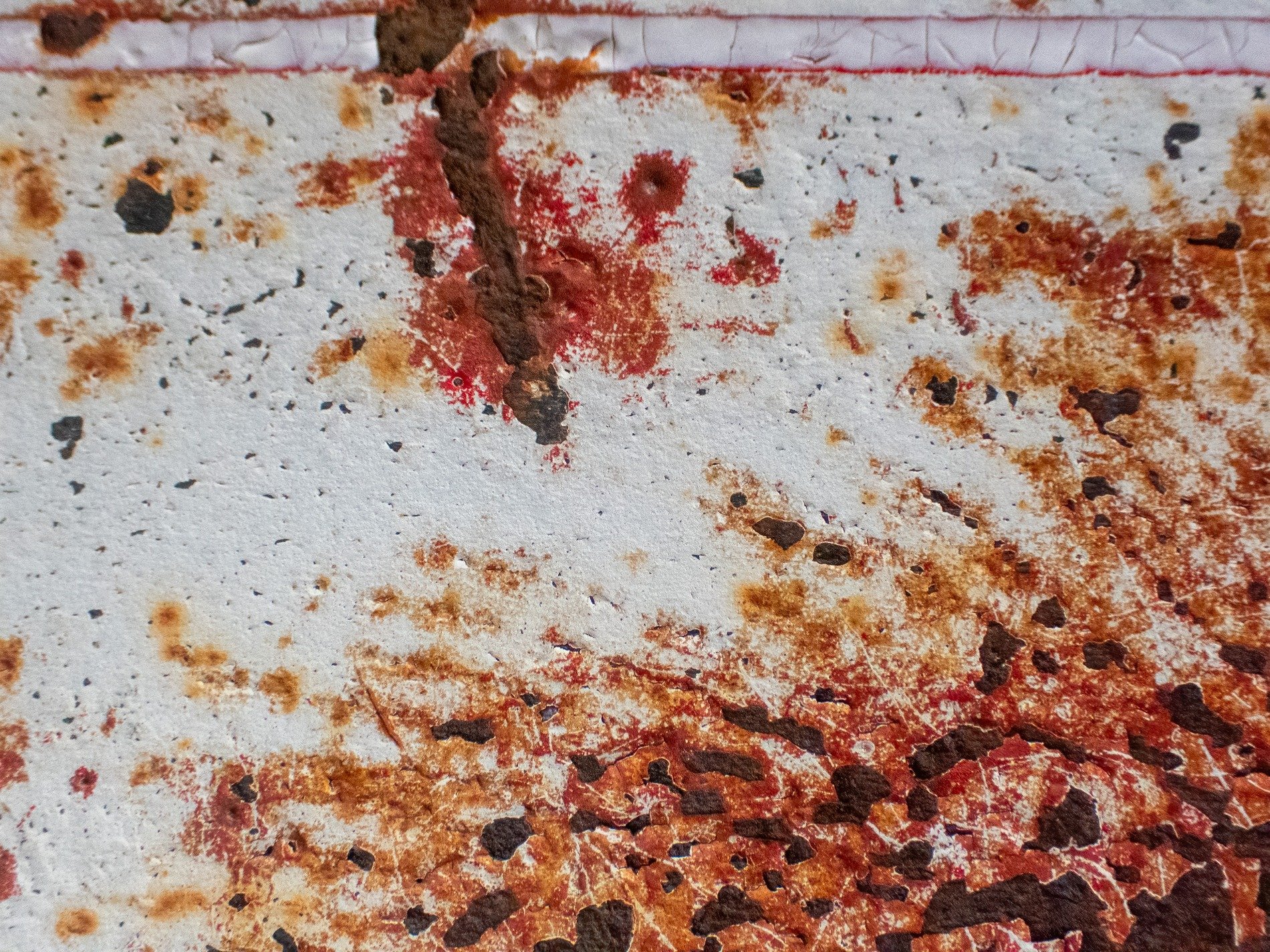 White paint flakes away, rusted iron bleeds through red, time stains the metal