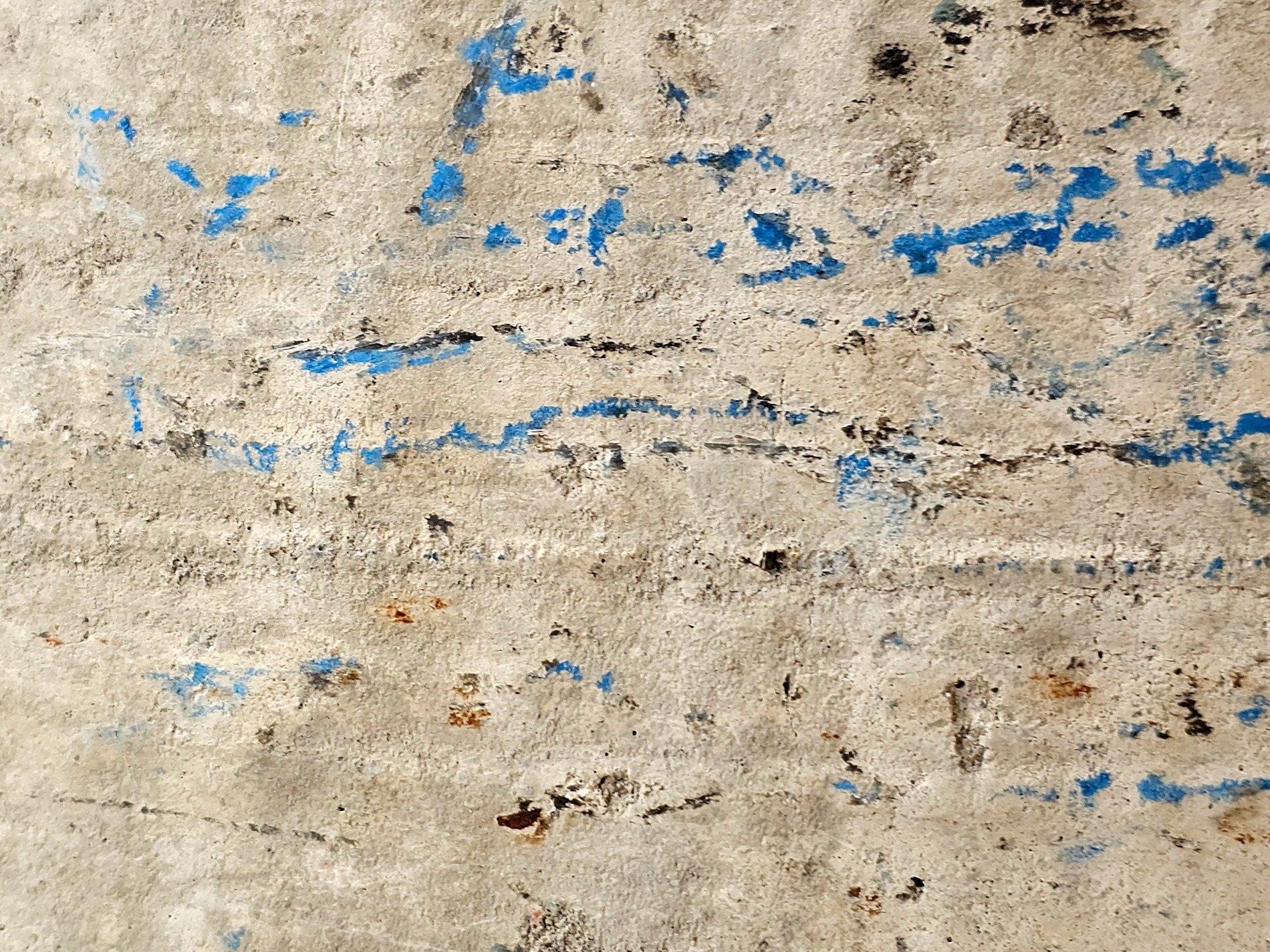 Blue paint fades away, rough concrete holds every scar, time leaves dusty marks