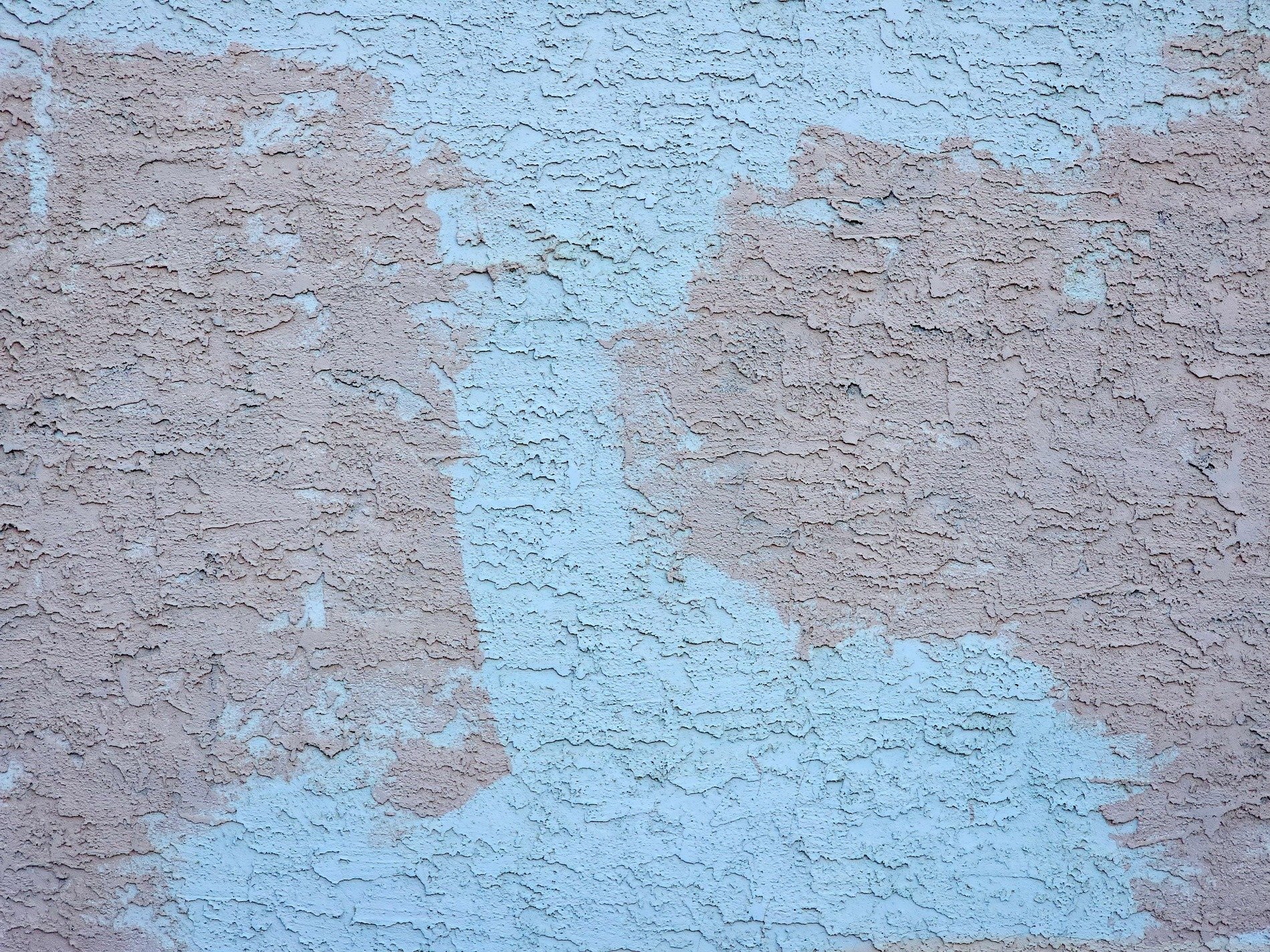 Blue paint fades away, rough pink stucco shows its grit, time wears down the wall