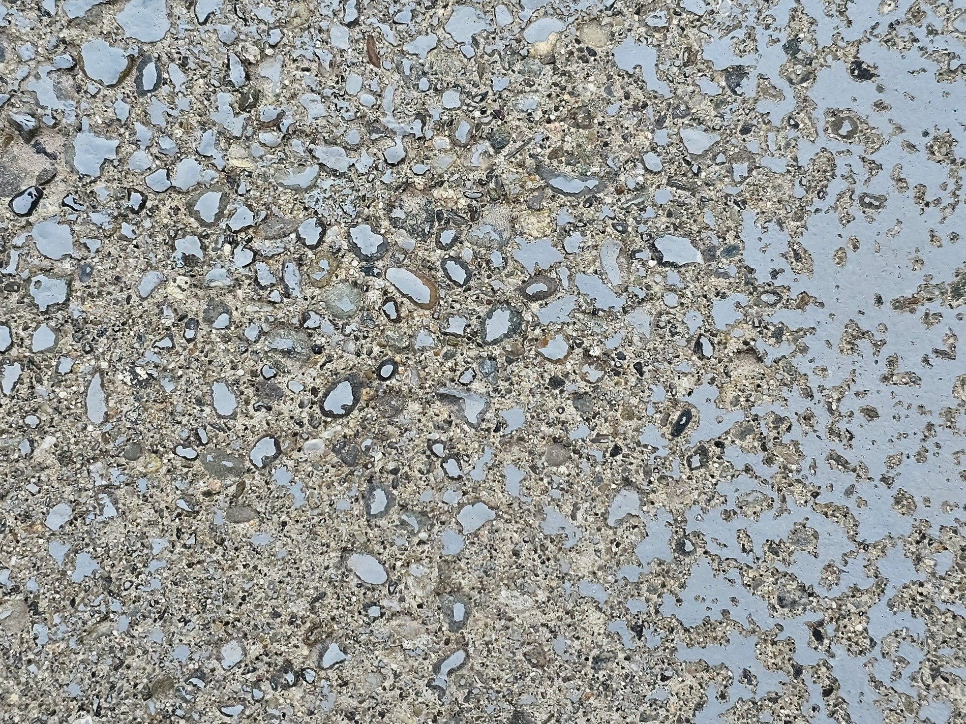 Blue paint flakes away, rough stone aggregate remains, weathered path holds fast