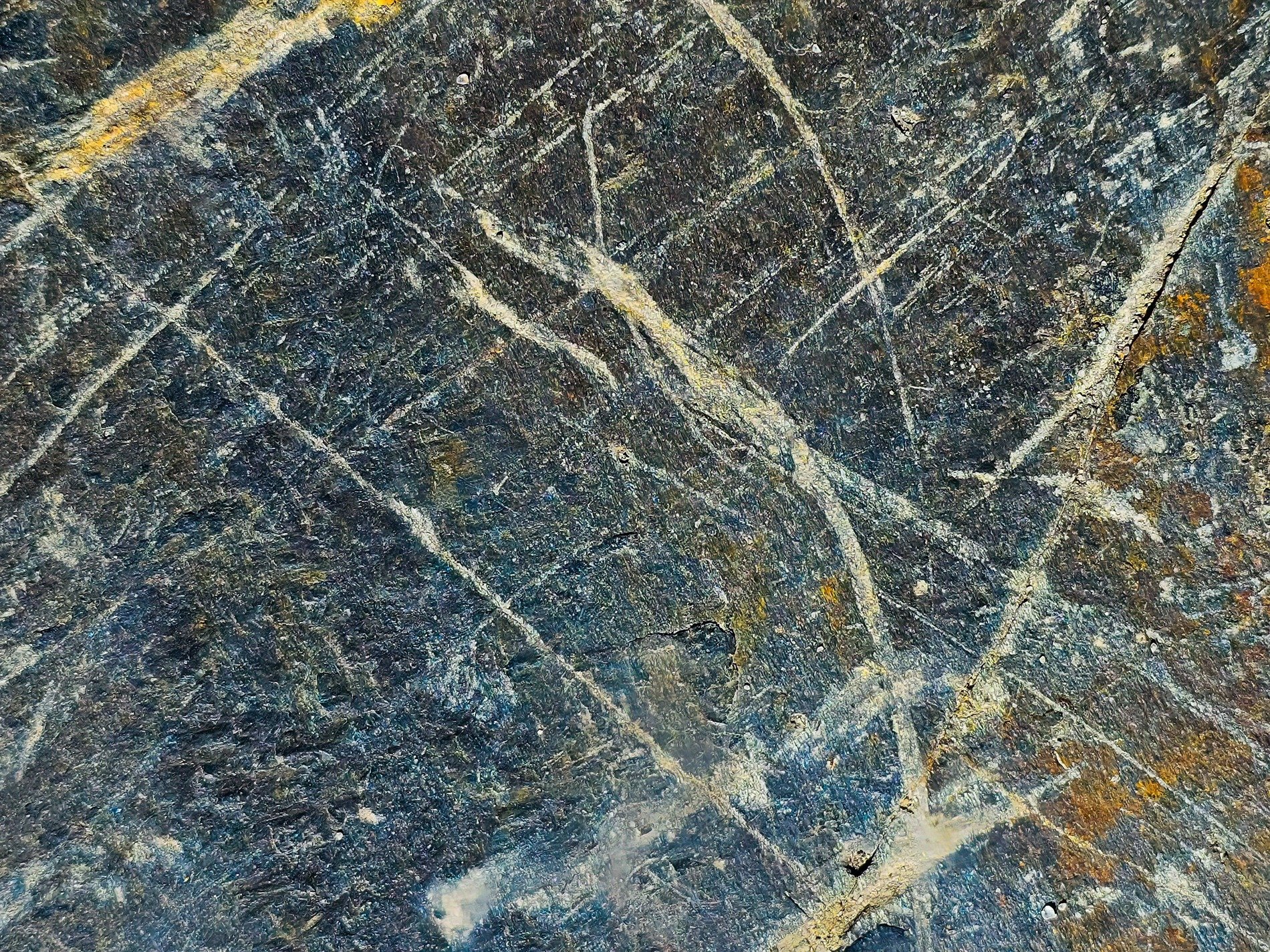 Dark stone holds the line, white veins cut through cold gray rock, ancient earth revealed