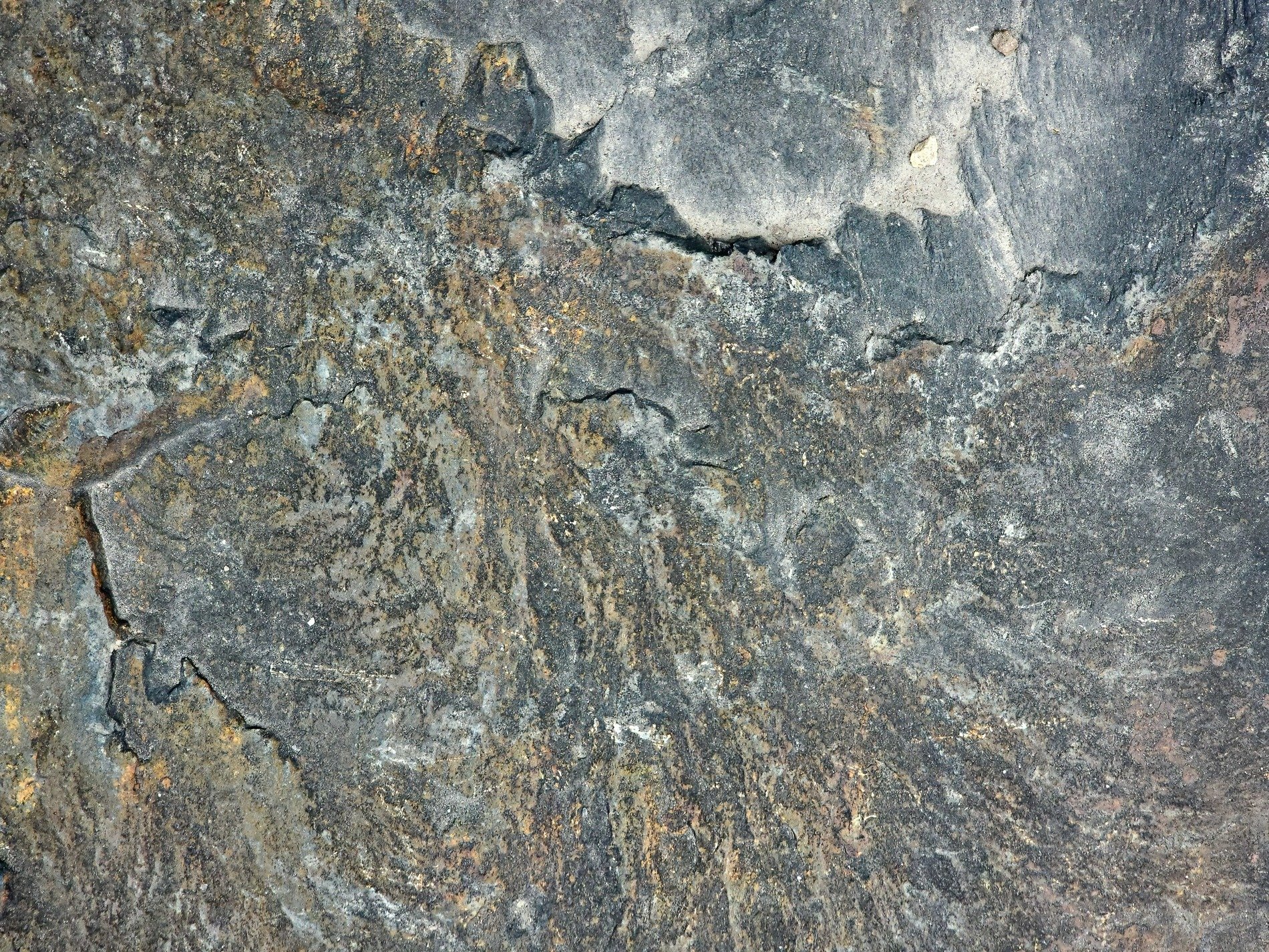 Dark stone wears its age, cracks run through the ancient face, iron bleeds in time
