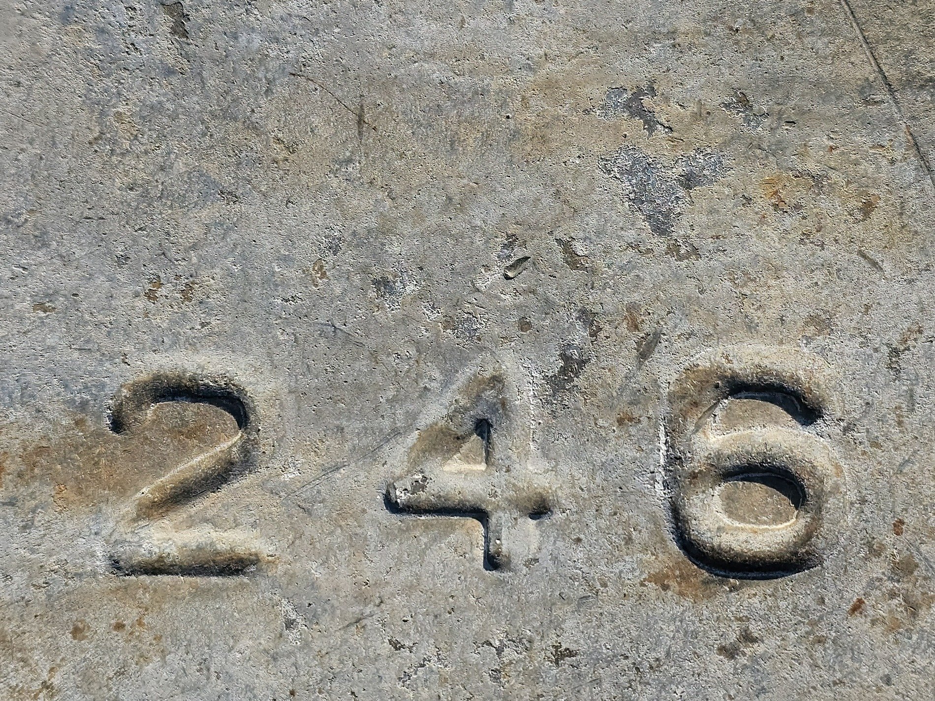 Even numbers set, deep within the weathered gray, grit and shadow blend