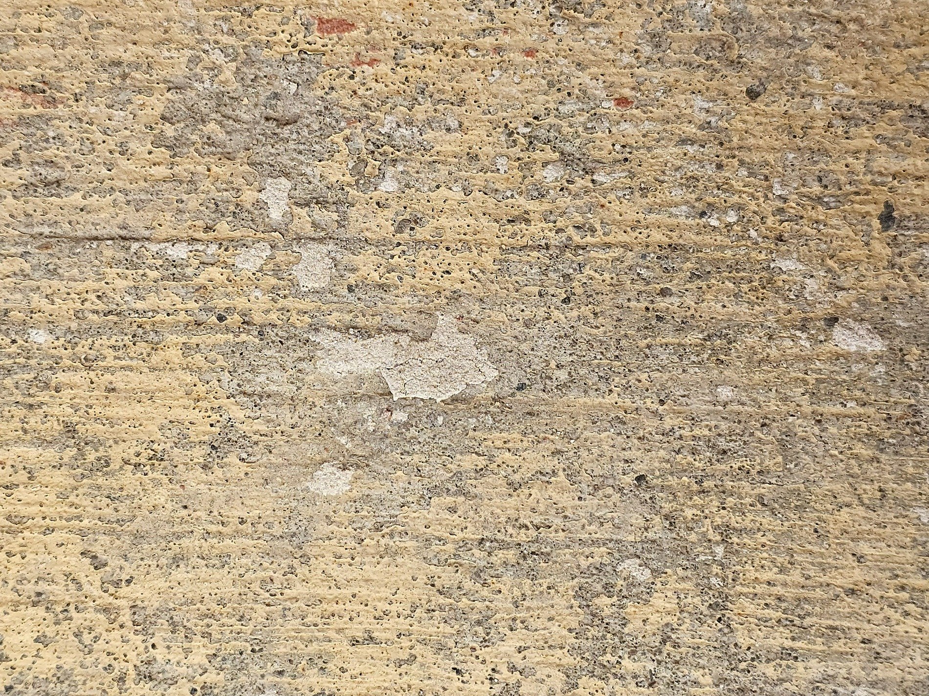 Faded yellow skin, rough stone breaks the painted shell, weathered surface speaks