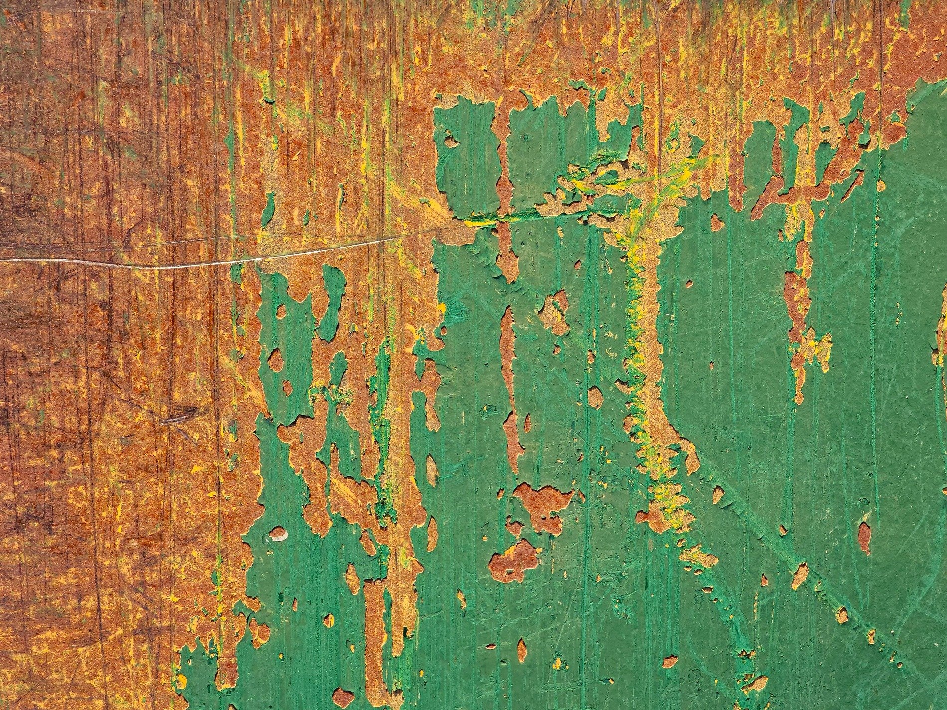 Green paint flakes away, orange rust eats the metal, time claims the surface