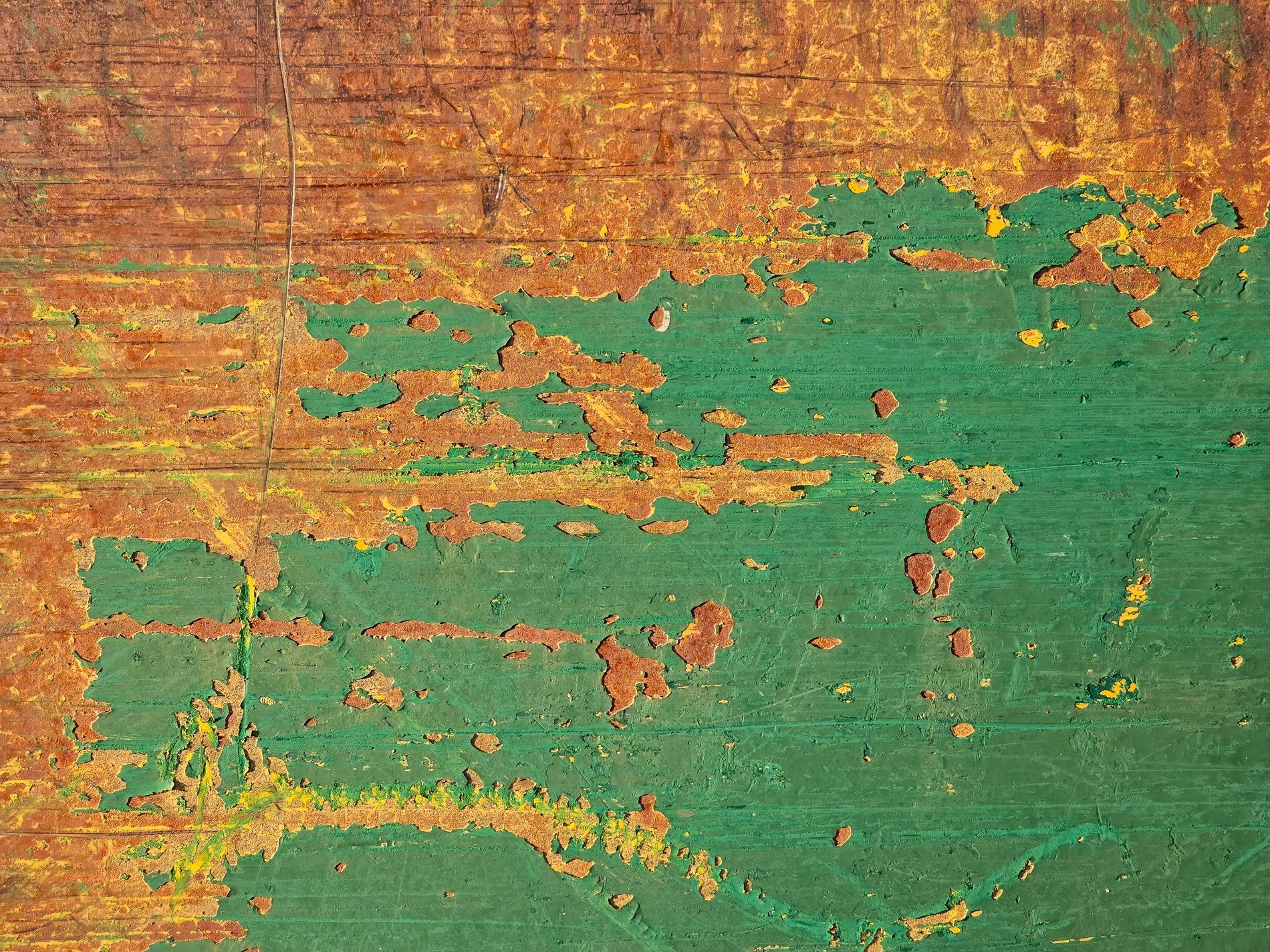 Green paint flakes away, rust spreads across the metal, time wears down the skin