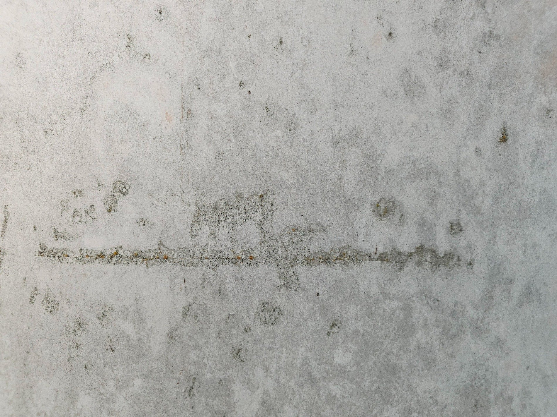 Grey concrete skin, horizontal scar etched deep, stains of time remain