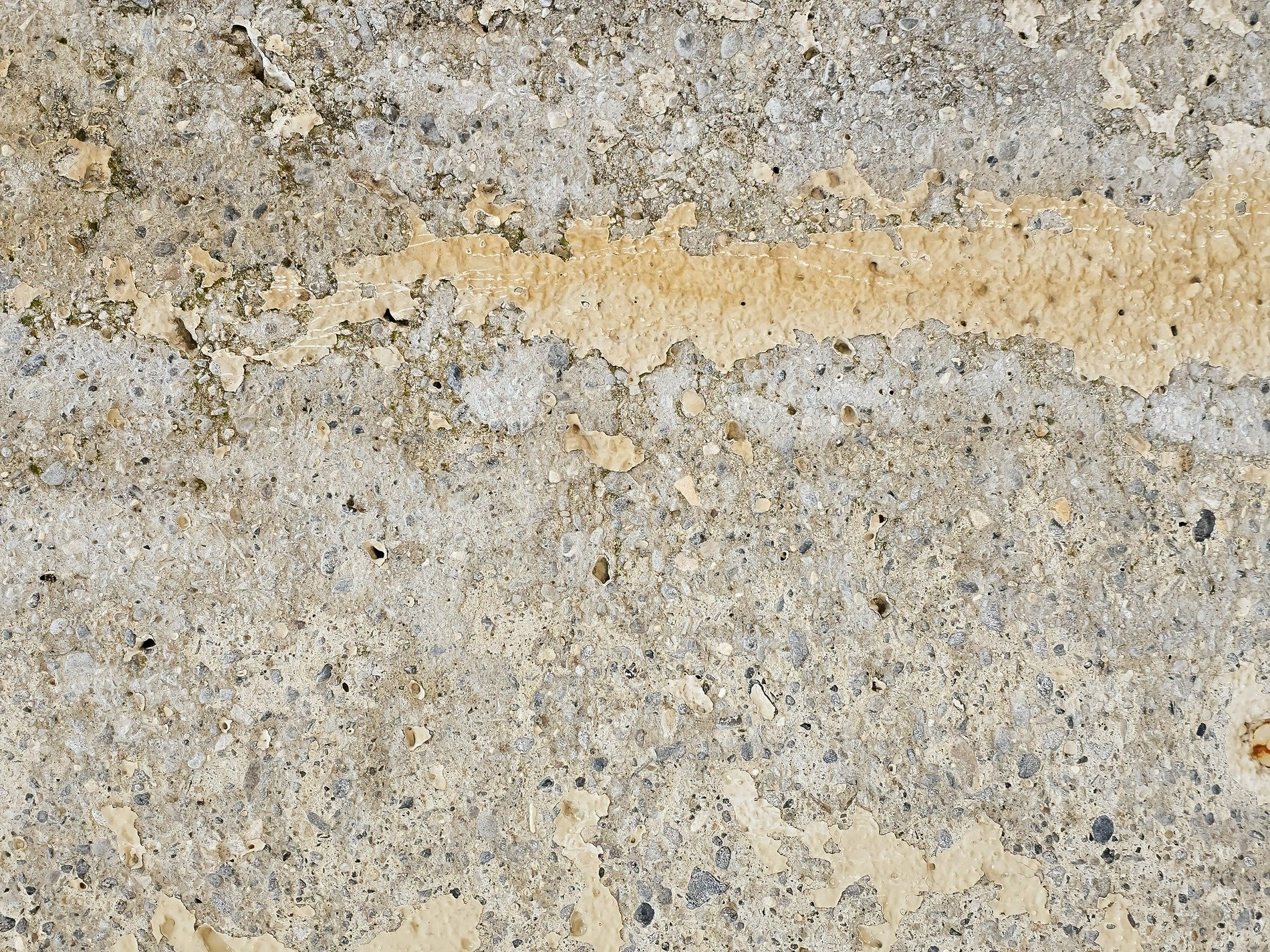 Grey stone meets the air, yellow paint peels from the wall, time erodes the face