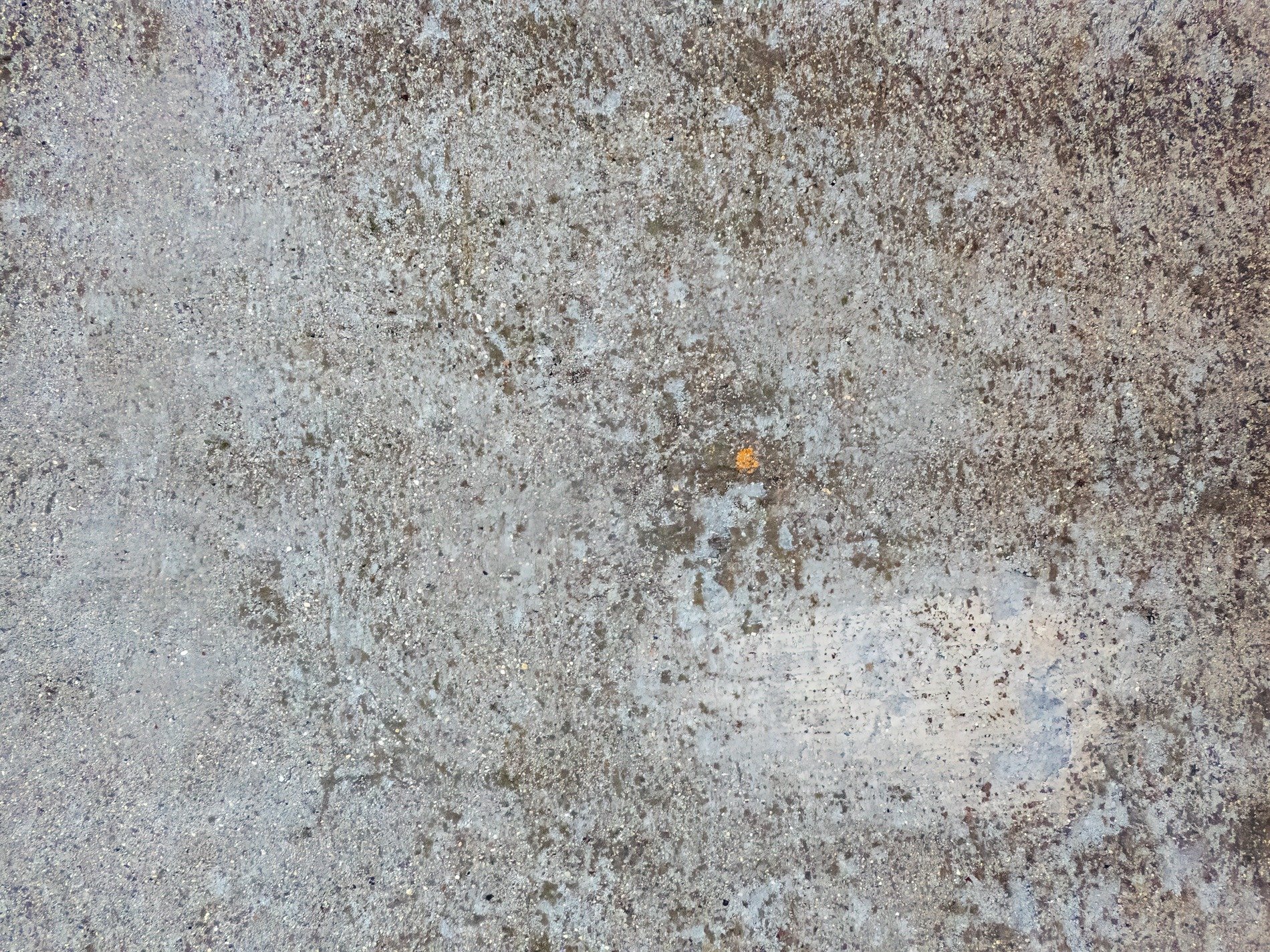 Grey stone weathered deep, grit and sand pressed in the floor, one small speck of rust