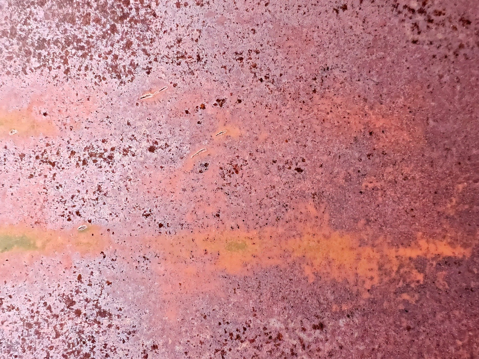 Red metal decays, orange streak across the face, texture born of time