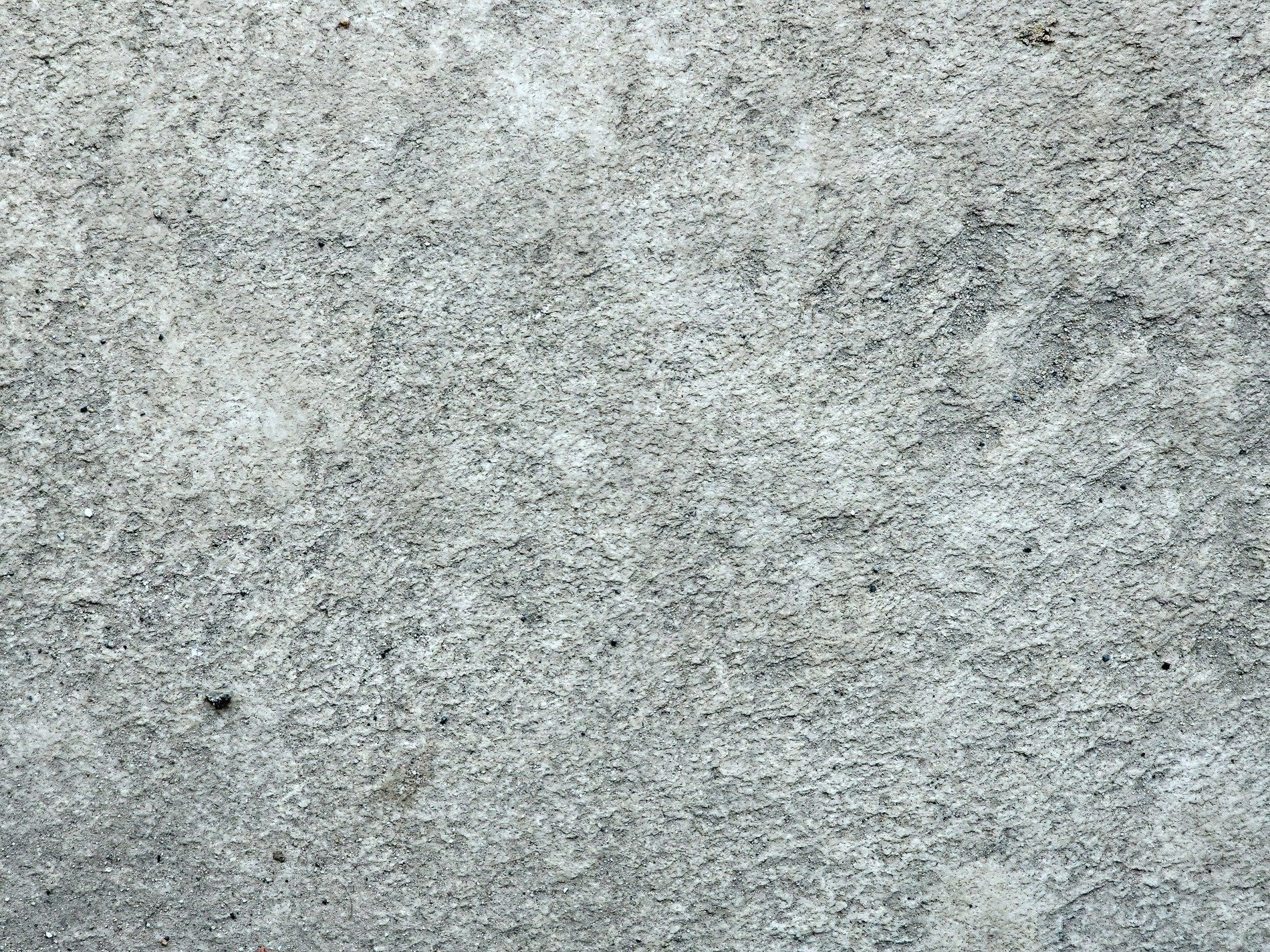 Rough grey concrete, pitted surface worn by time, cold and solid ground