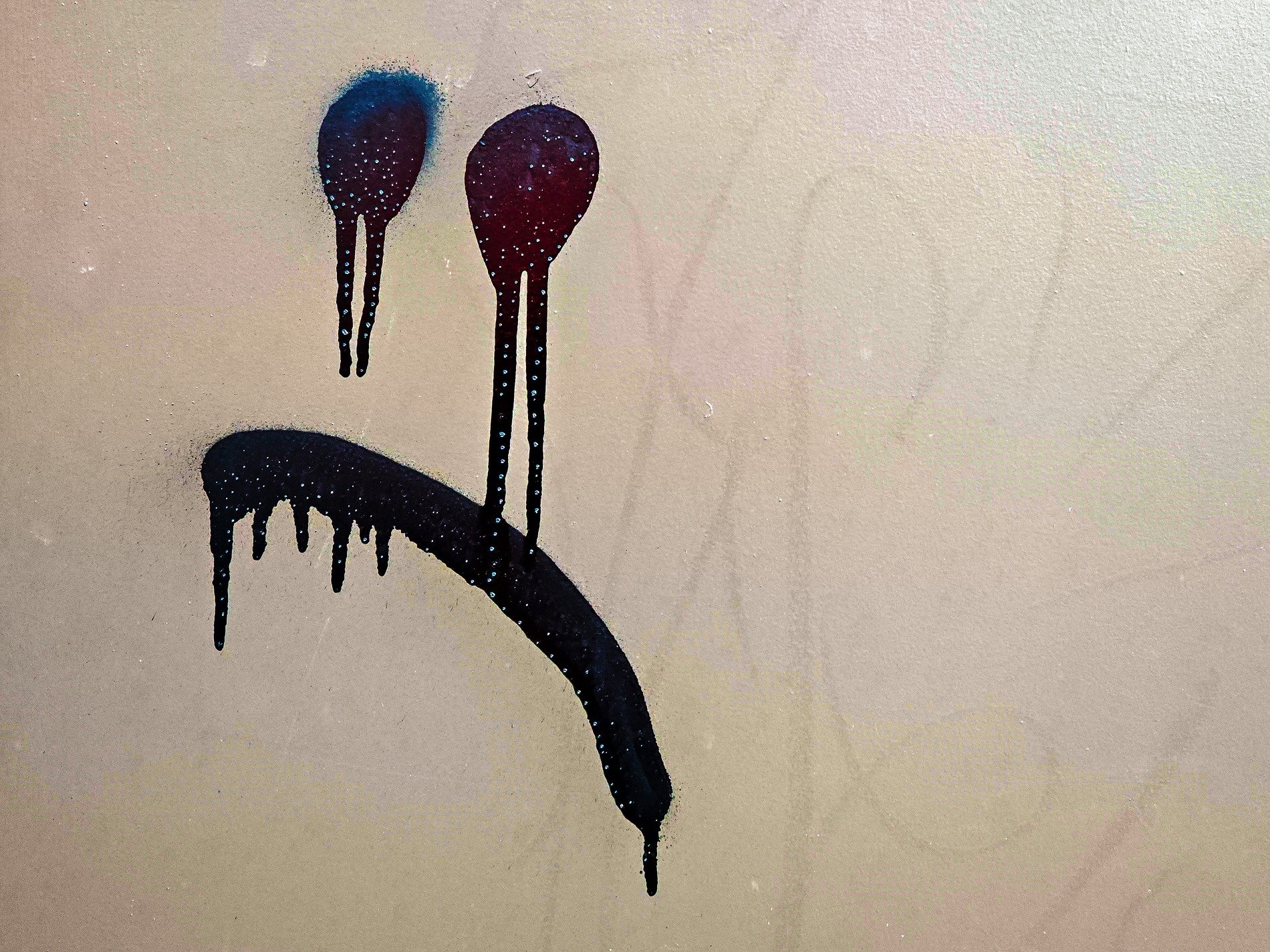 Spray paint starts to weep, sorrow stains the empty wall, dark drips trail below