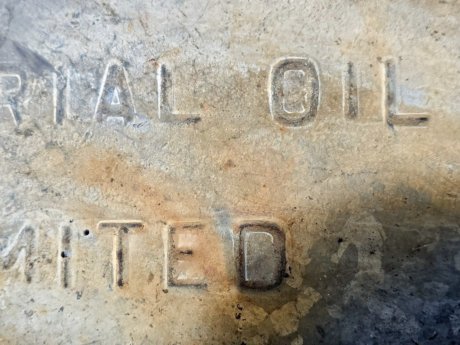 Stamped in heavy steel, rust stains the old industrial name, echoes of the past