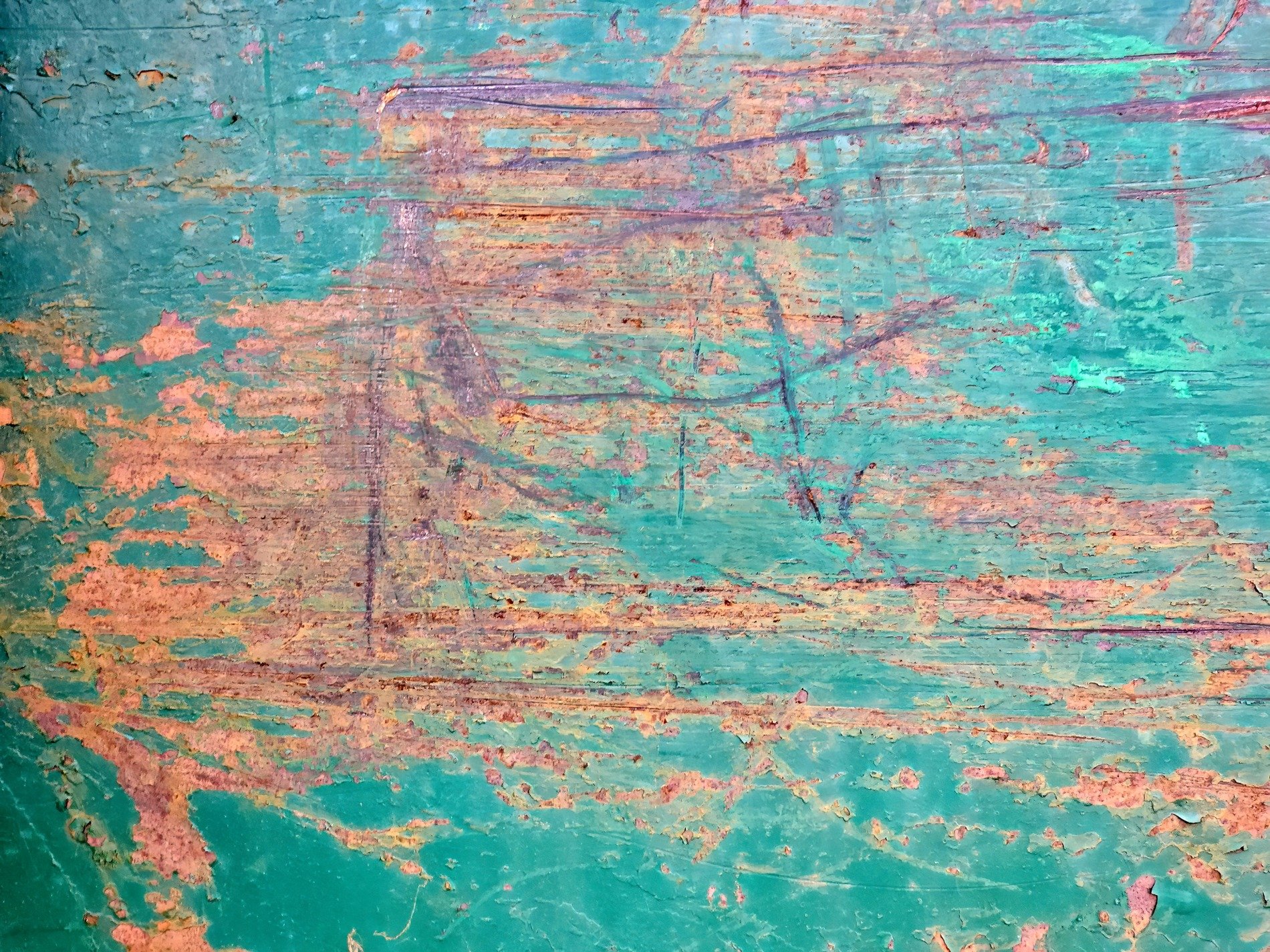 Teal paint peels away, rust crawls through the jagged lines, time scars the metal