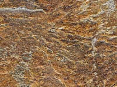 Ancient layers rest, iron rust bleeds through the cracks, stone holds onto time