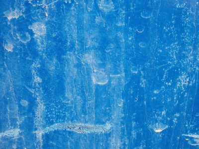 Azure surface scuffed, marks of time across the field, pale ghosts in the blue