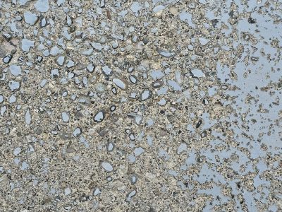 Blue paint flakes away, rough stone aggregate remains, weathered path holds fast