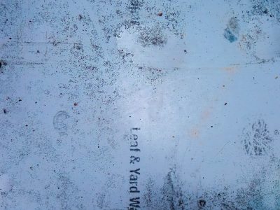 Blue sheet holds the dirt, yard waste text is fading fast, footprints leave their mark
