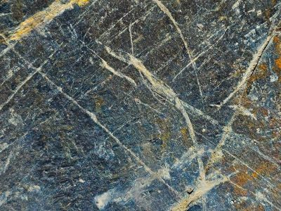 Dark stone holds the line, white veins cut through cold gray rock, ancient earth revealed