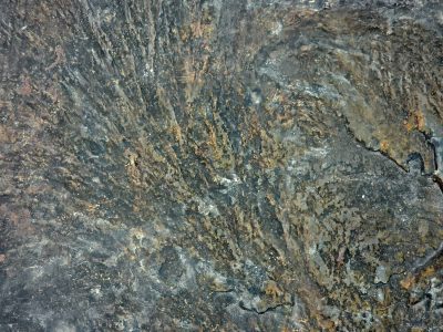 Dark stone swirls and flows, golden veins mark ancient heat, rough ridges hold time
