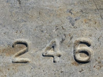 Even numbers set, deep within the weathered gray, grit and shadow blend