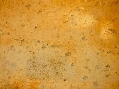 Golden surface fades, mottled stains across the plane, shadows leave their mark