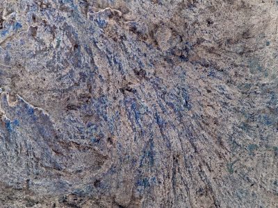 Gray concrete swirls deep, blue shadows stain the rough ground, marks of time remain