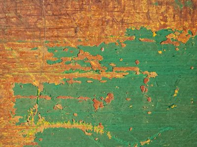 Green paint flakes away, rust spreads across the metal, time wears down the skin