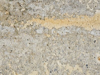 Grey stone meets the air, yellow paint peels from the wall, time erodes the face
