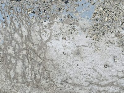 Grey stone starts to crack, frozen lines etch the surface, blue fades into dust