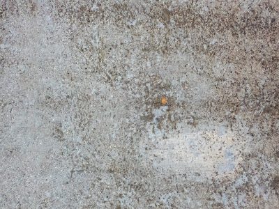 Grey stone weathered deep, grit and sand pressed in the floor, one small speck of rust