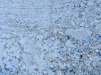 Pale blue paint fades out, rough concrete grit shows through now, time marks the surface