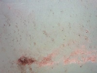 Pale concrete is scarred, red stains bloom across the grey, fine grit covers all
