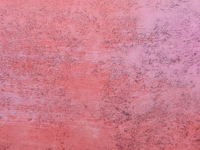 Pink paint starts to fade, scratched by time's relentless hand, rough texture remains