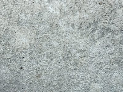 Rough grey concrete, pitted surface worn by time, cold and solid ground