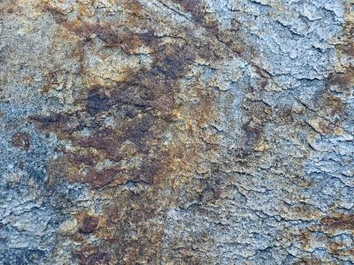 Rough layers of stone, ochre stains the ancient slate, time peels back the earth