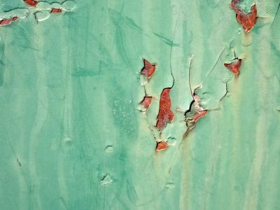 Teal paint curls and breaks, iron wounds bleed rusty red, time strips back the skin