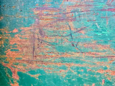 Teal paint peels away, rust crawls through the jagged lines, time scars the metal