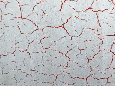 White paint splits apart, crimson glows in every gap, dry crust breaks the plane