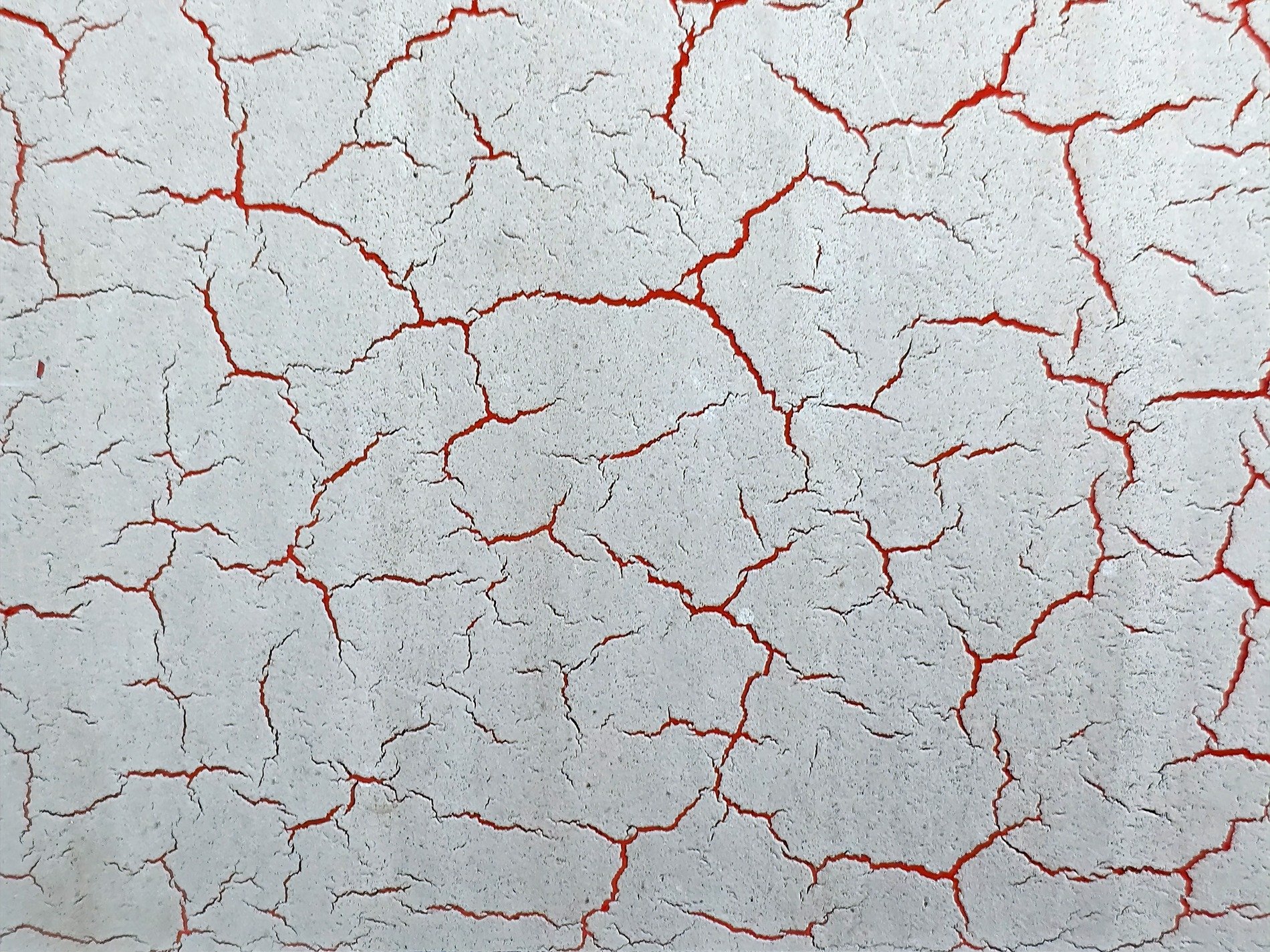 White paint splits apart, crimson glows in every gap, dry crust breaks the plane